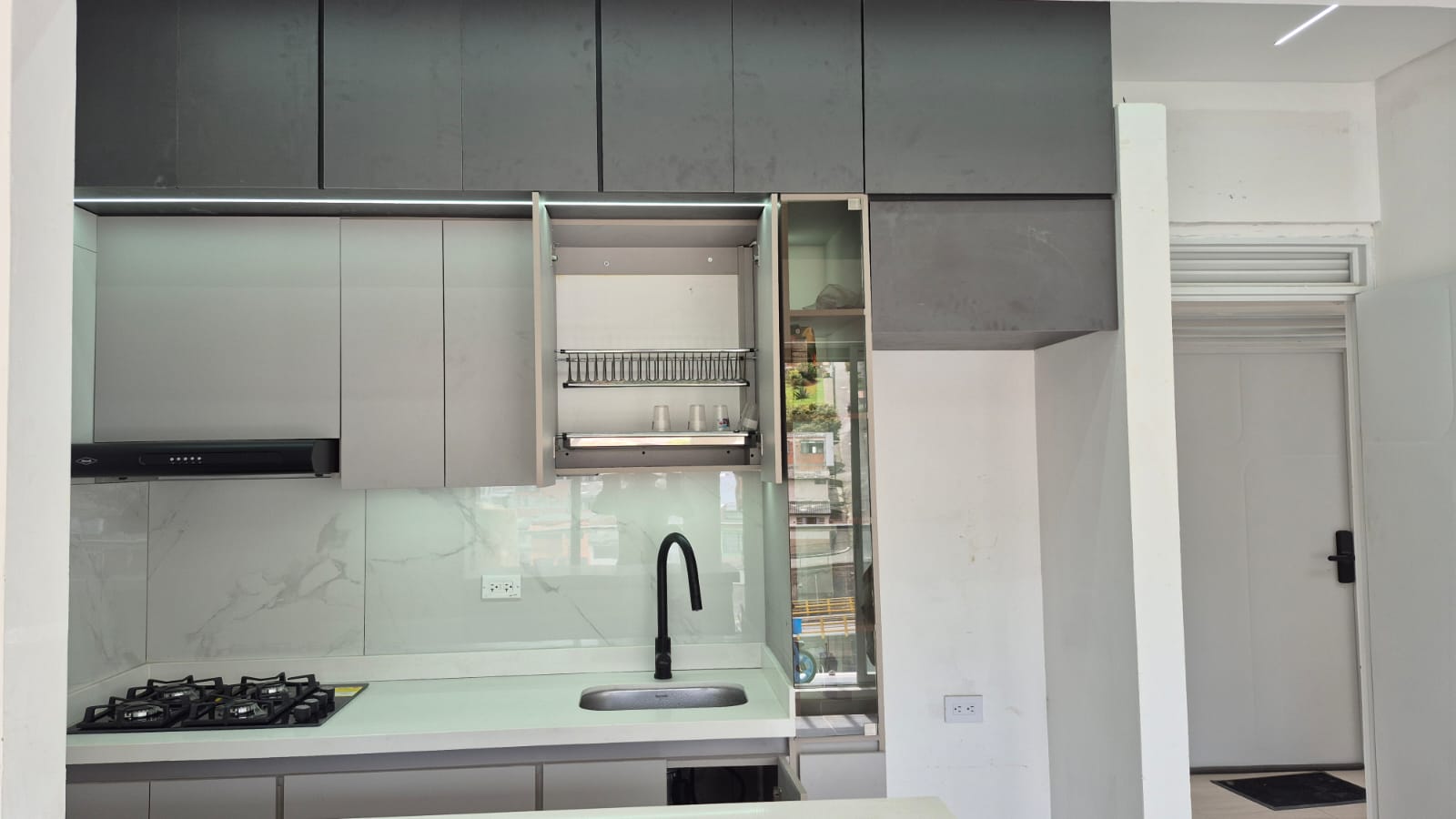 Cocina con mes?n y alacena abierta